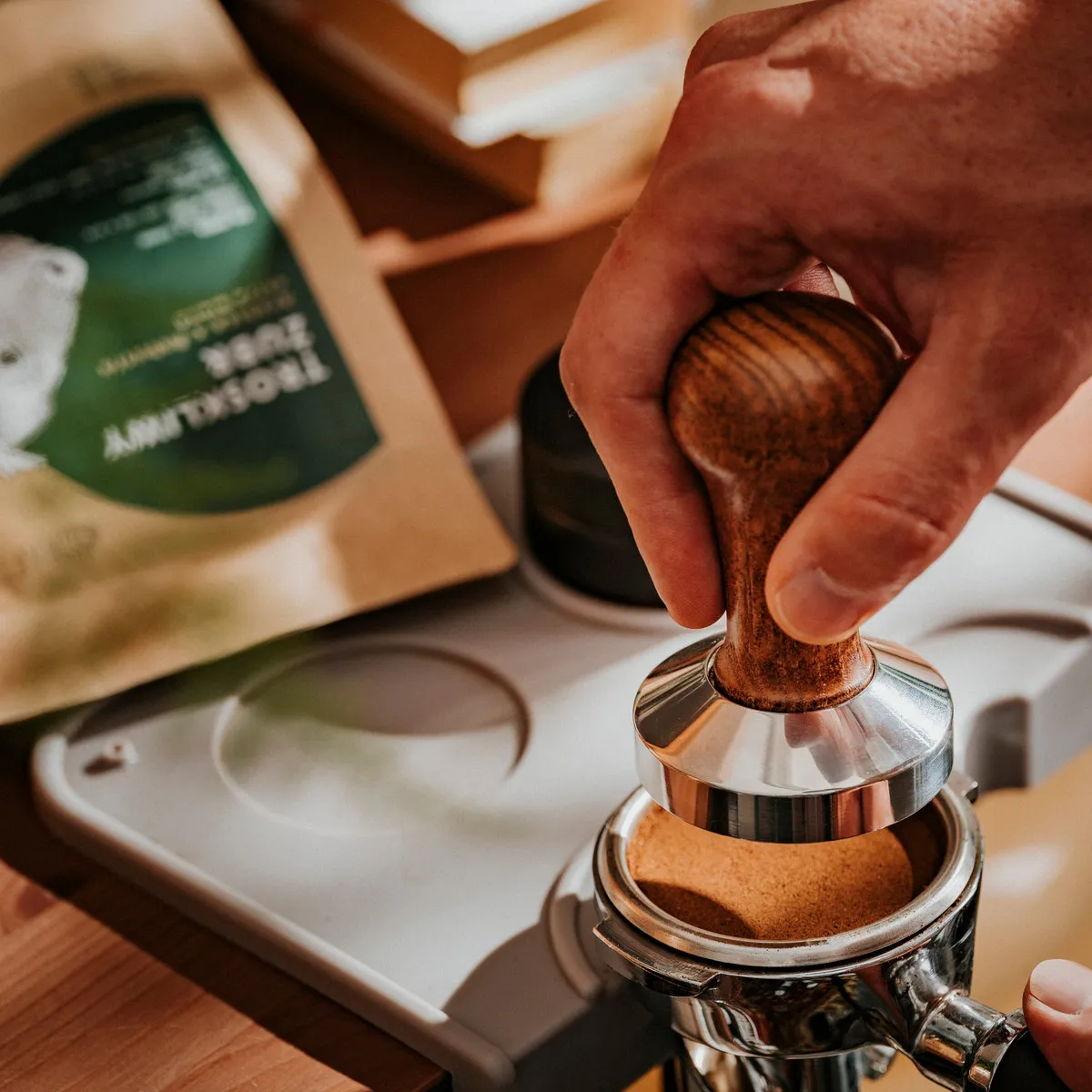 Troskliwy Żubr 1 kg, tamper w kolbie, paczka w tle