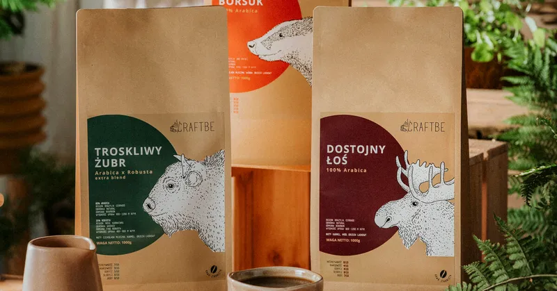Trzy paczki 1 kg, Troskliwy Żubr, Szykowny Borsuk i Dostojny Łoś, ręka sypie ziarna mosiężną miarką